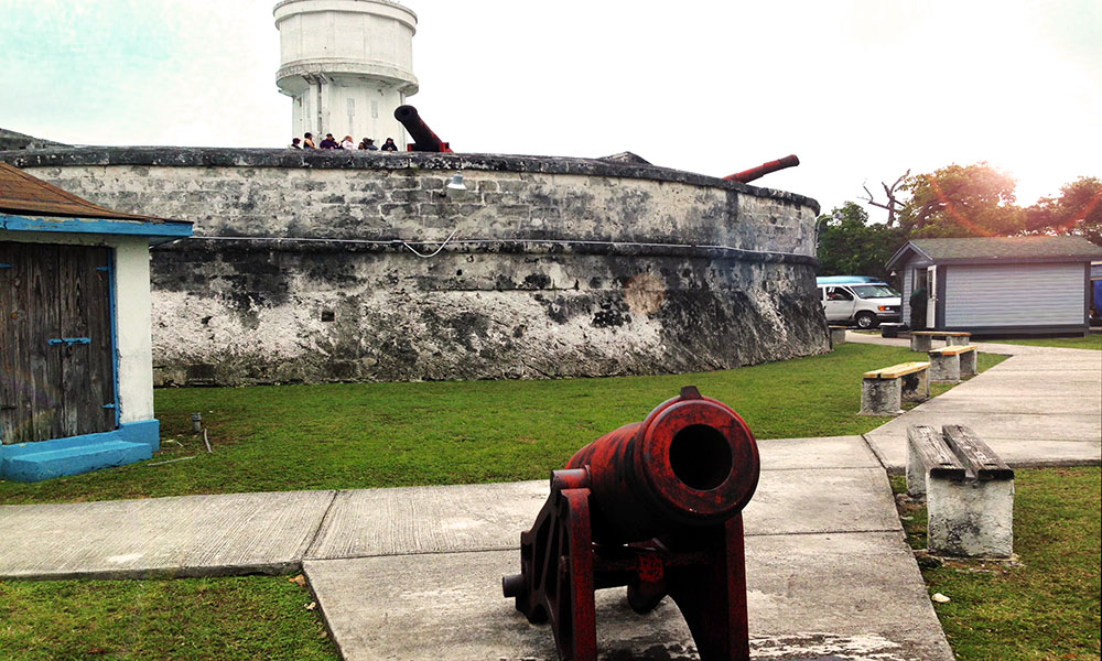 A bright red cannon beside the manicured lawns around Fort Fincastle, Nassau, Bahamas.