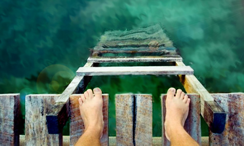 feet on the edge over water