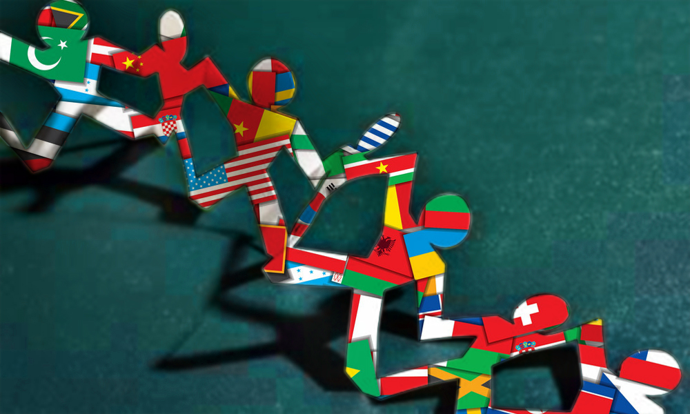 Paper dolls in a chain with world flags showing through